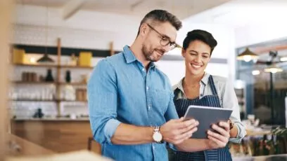 Un homme et une femme dans un restaurant regardant une tablette