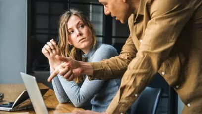 Un homme, probablement un manager, discutant avec sa salariée au regard froid.