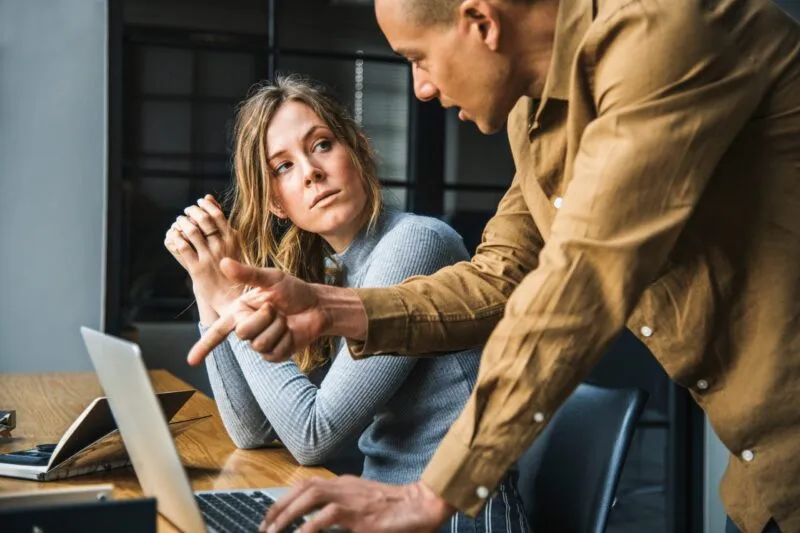 Un homme, probablement un manager, discutant avec sa salariée au regard froid.
