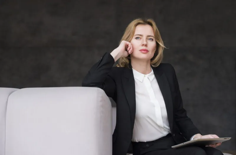 femme d'affaire blonde reflechie avec tablette