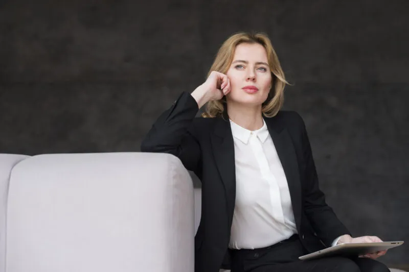 femme d'affaire blonde reflechie avec tablette