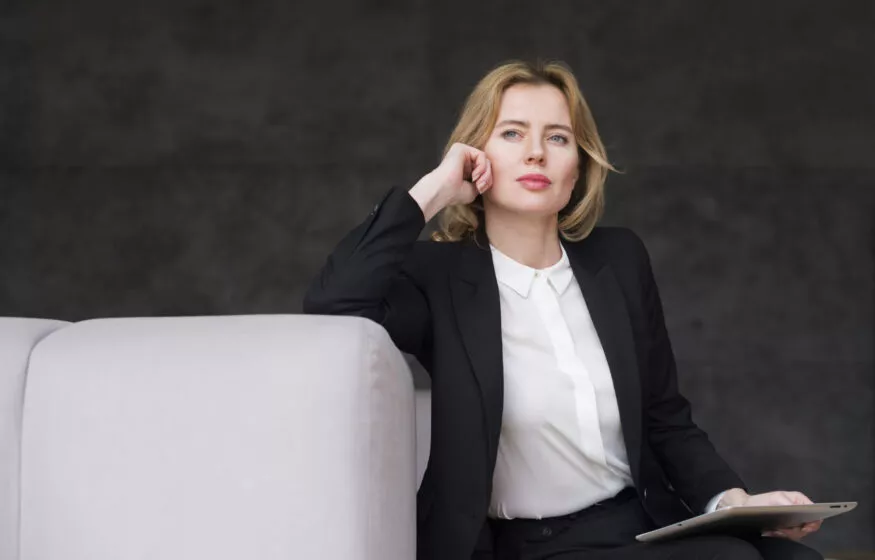 femme d'affaire blonde reflechie avec tablette