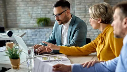 conseiller-financier-travaillant-sur-un-ordinateur-lors-d-une-reunion-avec-un-couple-au-bureau